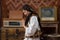 Waist up photo of a young woman in national white dress and black handkerchief who praying with closed eyes