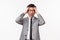 Waist-up portrait of desperate and depressed young sad asian male office manager in grey suit panic, grab head close