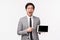 Waist-up portrait of excited, passionate handsome asian man in grey suit describe great income of his company, showing