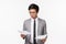 Waist-up portrait of serious-looking busy asian young businessman looking focused and determined at documents, reading