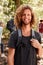 Waist up portrait of smiling millennial white man hiking in a forest, close up, vertical