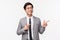 Waist-up portrait of successful, professional asian male entrepreneur, office clerk in grey suit, seeing pleasant