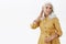 Waist-up shot of confident feminine and elegant old woman with white hair in stylish yellow trench coat touching haircut