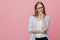 Waist up shot of contemplative young woman dressed in loose shirt, keeps hands partly crossed, wears optical glasses for good