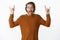 Waist-up shot of excited and thrilled overwhelmed attactive bearded man with wavy hair in sweater yelling from amazement