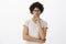 Waist-up shot of handsome stylish hispanic man with afro haircut and moustache in glasses, frowning, gazing with