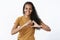 Waist-up shot of optimistic and caring young cute african american woman with curly long hair showing heart gesture and