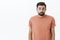 Waist-up shot of silly insecure and unconfident cute bearded guy in casual t-shirt shrugging looking gloomy and unaware