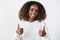 Waist-up shot of supportive and pleased african american female customer with curly hair in sweater showing thumbs up