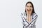 Waist-up shot of thrilled happy attractive mongolian woman with long natural dark hair, smiling broadly, holding palms