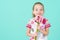 Waist up studio portrait of an adorable little girl holding bouquet of pink gerbera daisies. Happy Mother`s Day, Women`s day.