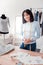 Waist up of young tailor standing in showroom