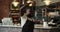 A waiter in a black apron in a doner market dances with wireless headphones. Video filmed in high quality