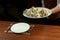 Waiter brings a plate of khinkali