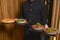 Waiter brings plates of traditional Gerogian meal. Khachapuri, meat and soup. Eating out in restaurant