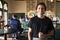 Waiter In Busy Cocktail Bar Of Restaurant With Customers At Camera