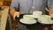 Waiter carries 3 cups of tea to the cafe visitors