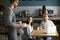 Waiter carrying coffee to smiling couple waiting at cafe table