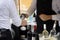 A waiter filling a glass with wine over the counter for a customer