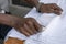 Waiter folds napkins in restaurant. Waiters hands with white napkin closeup