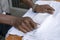 Waiter folds napkins in restaurant. Waiters hands with white napkin closeup