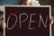 Waiter holding chalkboard, open restaurant business concept, clo