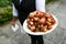 A waiter holding a plate full of bacon wrapped scallops - wedding catering series