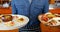 Waiter holding plate of mexican food in bar 4k