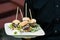 A waiter holding a platter of mini hamburgers - wedding catering series