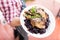 Waiter with large platter- duck confit and wine braised cabbage