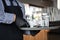 Waiter in a medical protective mask serves  the coffee in restaurant