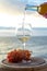 Waiter pouring aperitif white wine in glasses on outdoor tessace witn sea view
