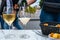 Waiter pouring of brut champagne sparkling wine into glasses in street cafe in old central part of city Reims, Champagne, France