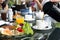 Waiter pouring coffee with breskfat set on table having fried eggs and vegetable salad with tea pot