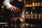 waiter pouring dessert wine into glass at upscale restaurant