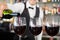 Waiter pouring wine into glasses