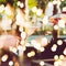 Waiter is pourring sparkling wine into a woman glass at the outdoor party. Celebration concept with festive bokeh lights