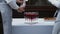 Waiter pours champagne into glass goblets, girl waiter brings plate of snacks