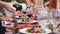 Waiter pours wine into glass. Banquet table with bright orange decor.