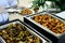 Waiter`s hands in sterile gloves with tongs and hot food