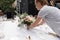 The waiter serves banquet table. Wedding table setting decorated with flowers and brass candlesticks with candles