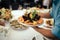 Waiter serves shrimp on the table