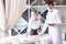 The waiter serves a table in a cafe in a protective mask