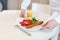 Waiter serving breakfast on a white plate scrambled eggs and sausage