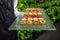 Waiter serving canape dessert selection on slate platter. desserts on a glass tray