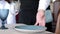 A waiter serving a customer in a restaurant. Close-up of a waiter puts a plate of dessert on the table in an elite