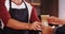 Waiter serving a glass of cold coffee to customer at counter