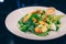 Waiter serving Guacamole with king prawn and  Herbs Letuce salad asparagus at restaurant, close up view. Eating organic and leisur