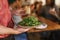 Waiter serving a healthy salad to restaurant customers