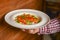 Waiter serving rice with red, green and yellow pepper, tomatoes, red onion, celery. Restaurant service.